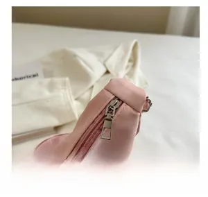 Détail de la fermeture éclair fluide sur un sac cabas en satin rose effet soyeux