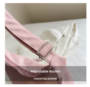 Vue détaillée de la boucle en métal réglable sur un sac cabas rose aux coutures soignées