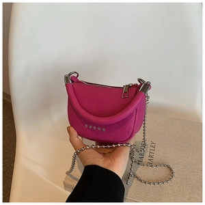 Détail du mini sac selle rouge rose à grain de litchi avec étoile et chaîne à billes