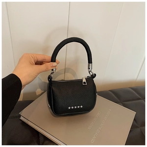 Détail du mini sac à main en cuir grainé noir avec cinq étoiles argentées et ferrures en métal
