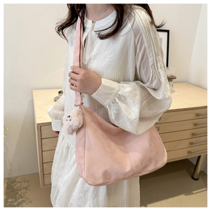 Détail du sac cabas rose avec large bandoulière et pendentif en peluche douce