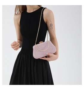 Detail of pink sequin evening clutch bag with gold chain strap for elegant party wear