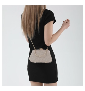 Close-up of sparkling champagne evening bag with metallic handle and crossbody chain