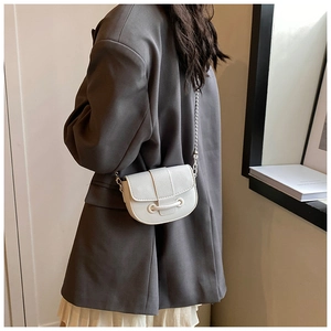 Détail du sac à main blanc en cuir grainé avec bandoulière chaîne sur modèle