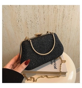Detail of black glitter clutch bag with gold frame and vintage clasp closure