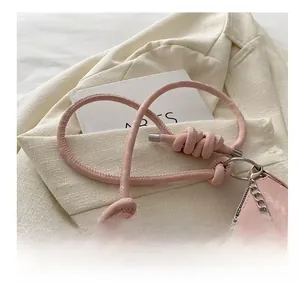 Détail du sac à bandoulière rose marbré avec une bandoulière à nœud au design unique