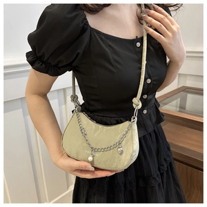Trendy saliegroene halve maan crossbodytas met zilveren ketting en parelhanger