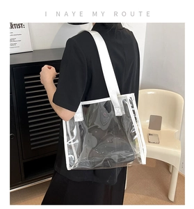 Detail of transparent PVC tote bag featuring white borders and reinforced shoulder straps