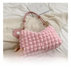 Detailed macro view of pink bubble texture bag with braided strap and floral charm