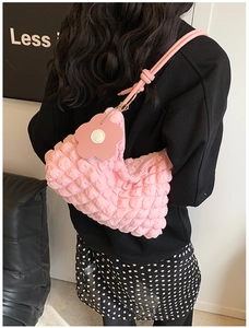 Pink pleated bubble shoulder bag featuring a cute flower pendant on a female model