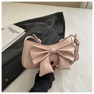Dettaglio borsa sottobraccio rosa chiaro con grande fiocco e accenti in metallo oro