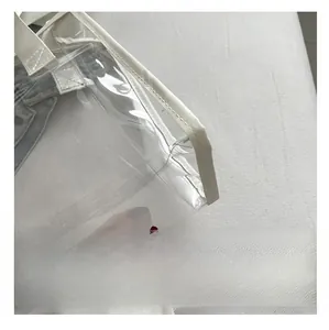 Detail of transparent PVC tote bag with white trim showing premium texture and large capacity