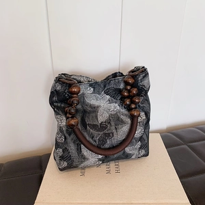 Artistic black underarm bag with white butterfly embroidery and wooden bead handle