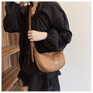 Detail of brown PU leather hobo bag with adjustable strap and vintage texture