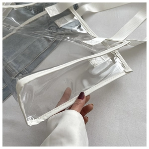 Detail of the white fabric trim and sturdy stitching on a clear PVC tote bag