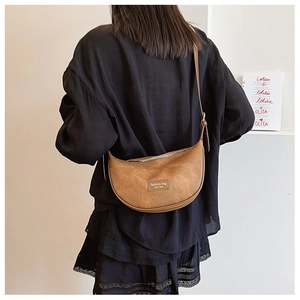 Brown moon-shaped crossbody bag with fashion label shown from a back perspective