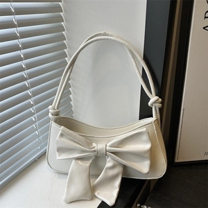 Elegant white bow shoulder bag with sleek PU leather texture in soft natural lighting