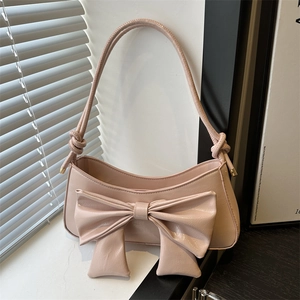 Pink bow shoulder bag with sleek finish and decorative knots for a chic feminine style