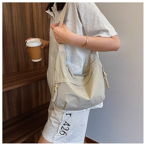 Detail der beige Hobo-Tasche mit plissierter Nylon-Textur und dekorativem Flecht-Reißverschluss