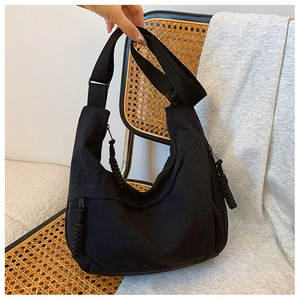 Nahaufnahme der schwarzen Nylon-Tasche mit gewebten Reißverschluss-Details und Gurt