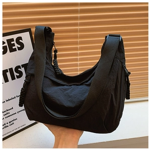 Detailansicht der großen schwarzen Nylon-Halbmondtasche mit breitem Gurt und Webzippern