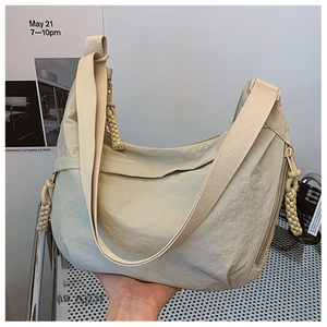 Detail der beigefarbenen Nylon-Hobo-Tasche mit Stofftextur und gewebtem Reißverschluss
