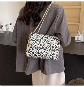 Détail du sac à main en toile léopard noir et blanc avec bandoulière dorée