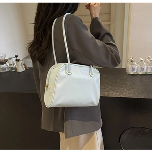 Detailed view of light blue shoulder bag with slim round straps and side gold zipper