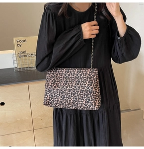 Détail du sac à main léopard avec bandoulière en chaîne dorée sur une robe noire