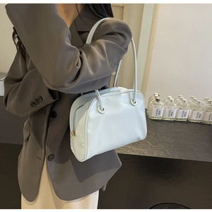 Close-up of light blue leather shoulder bag with a minimalist design and slender strap