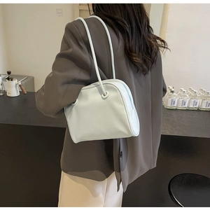 Pale blue minimalist faux leather shoulder bag shown on model in a retro style setting