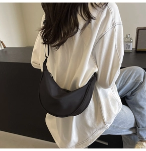 Sac bandoulière en nylon noir en forme de croissant porté avec bandoulière réglable