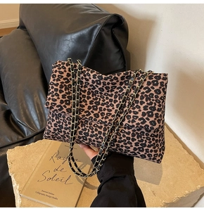 Détail du sac léopard avec bandoulière en chaîne dorée et texture en toile vintage