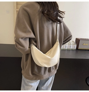 Sac bandoulière demi-lune en nylon beige minimaliste porté par un mannequin, vue arrière