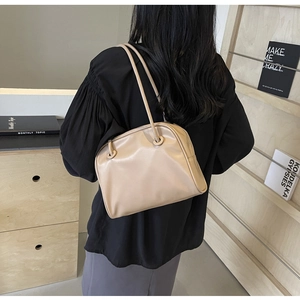Close-up of minimalist nude leather tote bag with thin dual straps shown on model