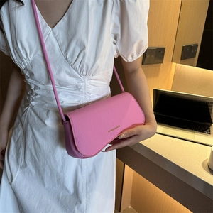 Sac bandoulière rose à motif crocodile avec rabat incurvé et logo métallique tendance