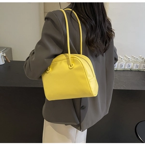 Model wearing a bright yellow tote bag showing size and fit from a back view