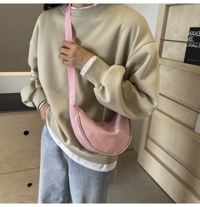 Photo du sac bandoulière en nylon rose en forme de croissant porté par un mannequin