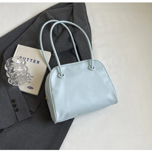 Close-up of light blue minimalist tote bag with premium leather texture and zipper detail
