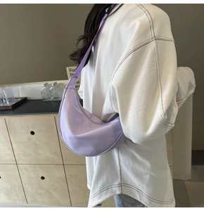 Gros plan du sac en nylon croissant violet clair avec bandoulière réglable sur modèle