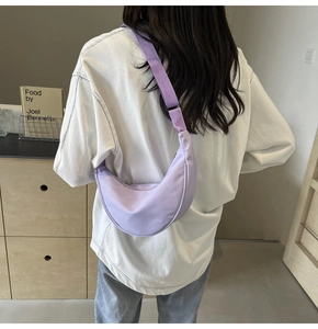 Vue de dos d'un mannequin portant un sac demi-lune en nylon violet clair dans un salon