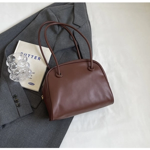 Detail view of smooth dark brown leather tote bag with elegant slim shoulder straps