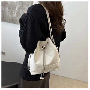 Détail du sac seau blanc avec texture marbrée et fermoir papillon en métal élégant