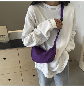 Détail du sac bandoulière croissant en nylon violet avec sangle réglable sur modèle
