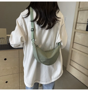 Vue arrière d'un sac bandoulière en nylon vert sauge avec sangle réglable sur mannequin