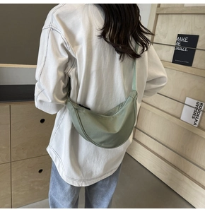 Détail du sac croissant en nylon vert clair avec bandoulière réglable sur modèle