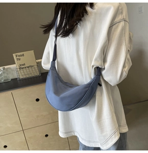 Sac croissant en nylon bleu porté par un mannequin avec un t-shirt blanc décontracté