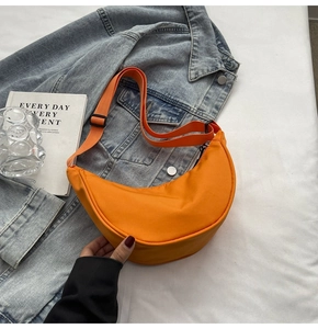 Détail du sac bandoulière croissant en nylon orange vif avec sangle réglable