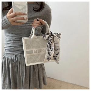Detail der floralen Totebag mit FASHION-Text und dekorativem Seidenschal-Griff