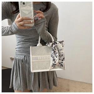Gros plan détaillé d'un grand cabas gris avec texte FASHION et foulard en soie sur l'anse